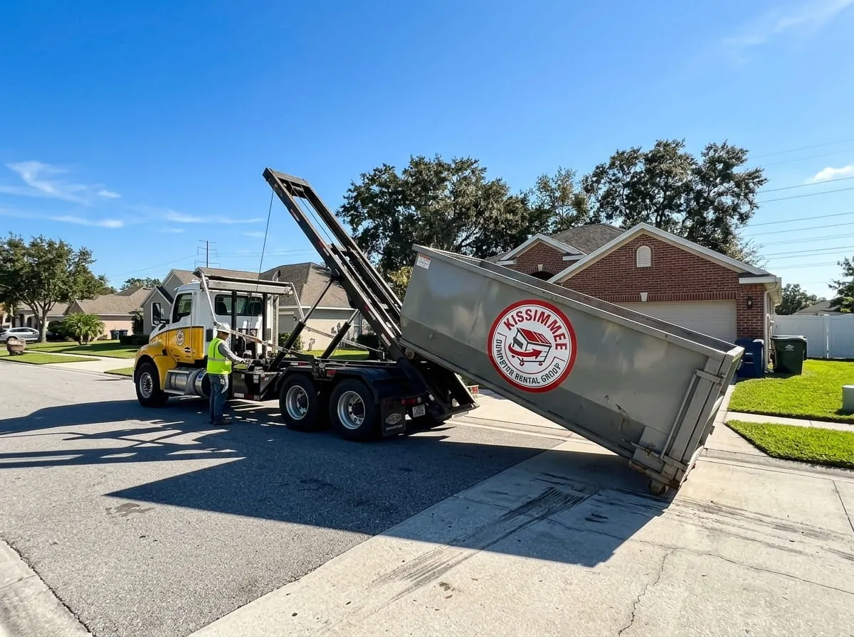 Roll-off truck lowering a red dumpster into position on a Kissimmee property